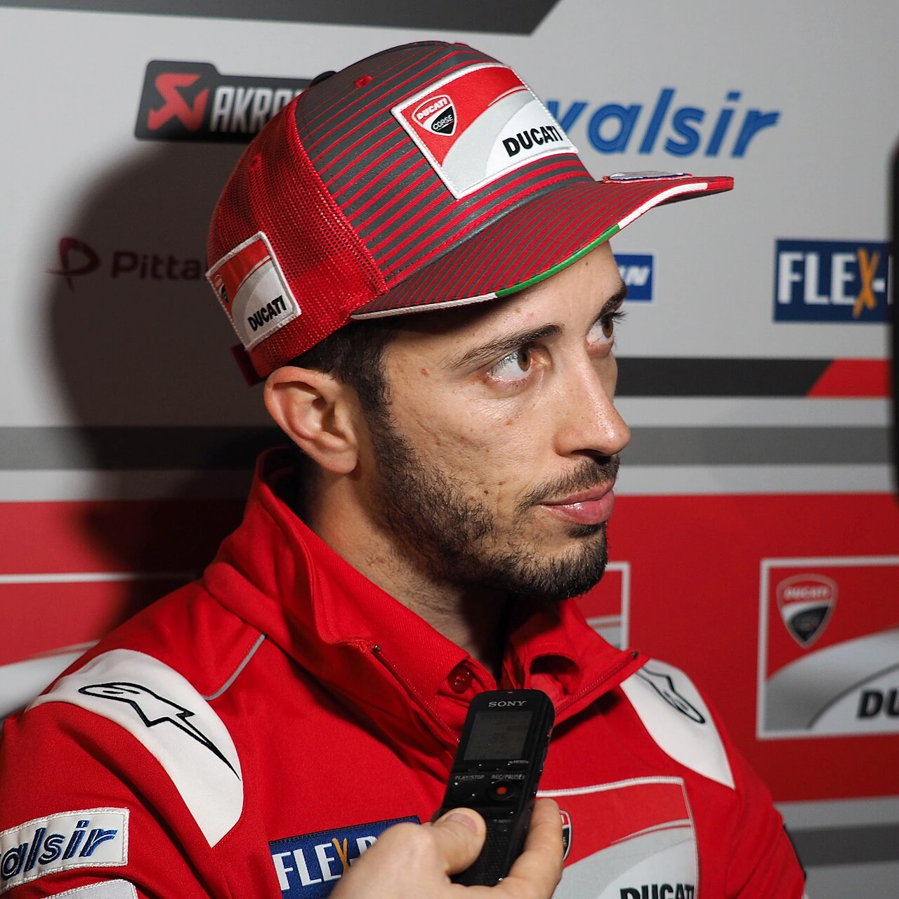 Andrea Dovizioso in a MotoGP paddock interview portrait wearing Ducati gear
